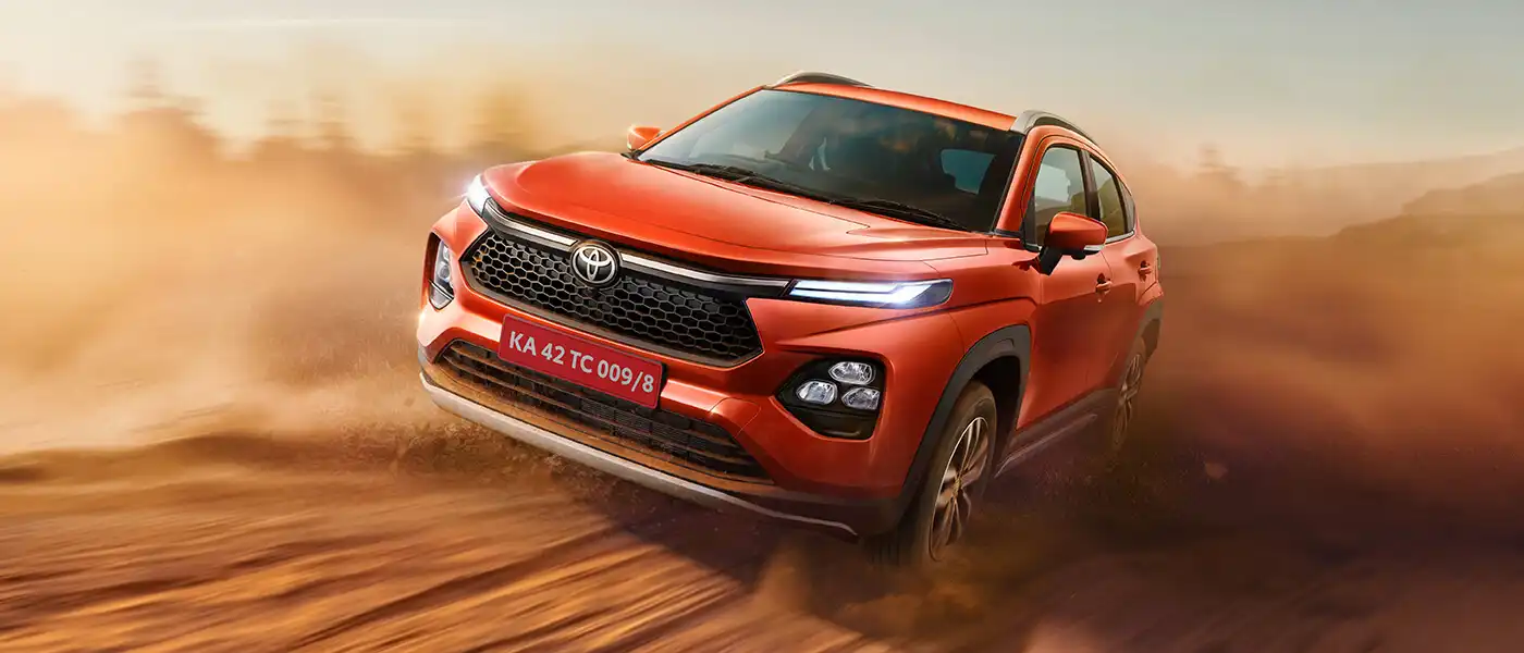 Toyota Urban Cruiser Taisor cornering on a dirt trail, kicking up dust